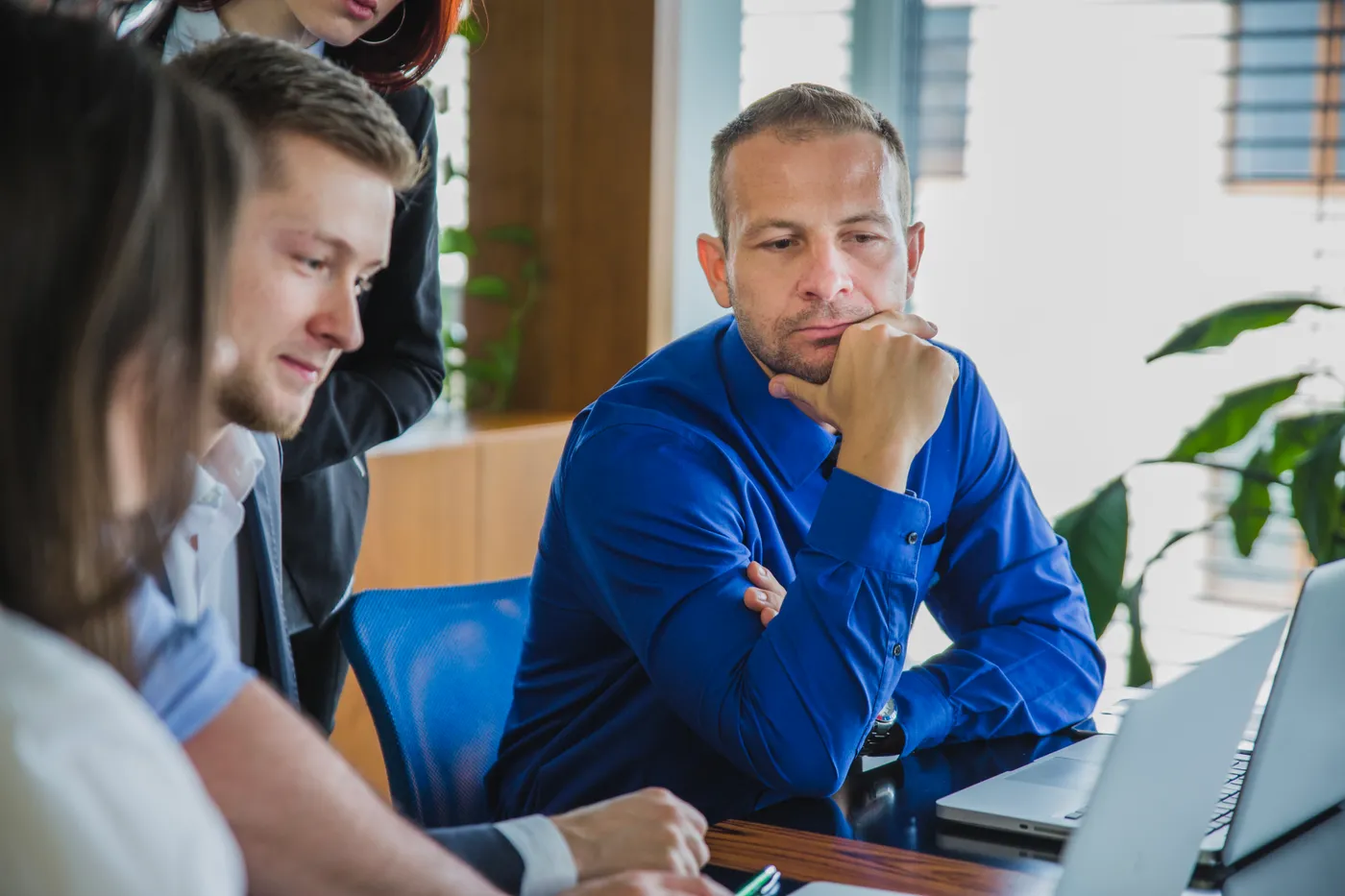 Une équipe examine ensemble des informations affichées sur un ordinateur portable.