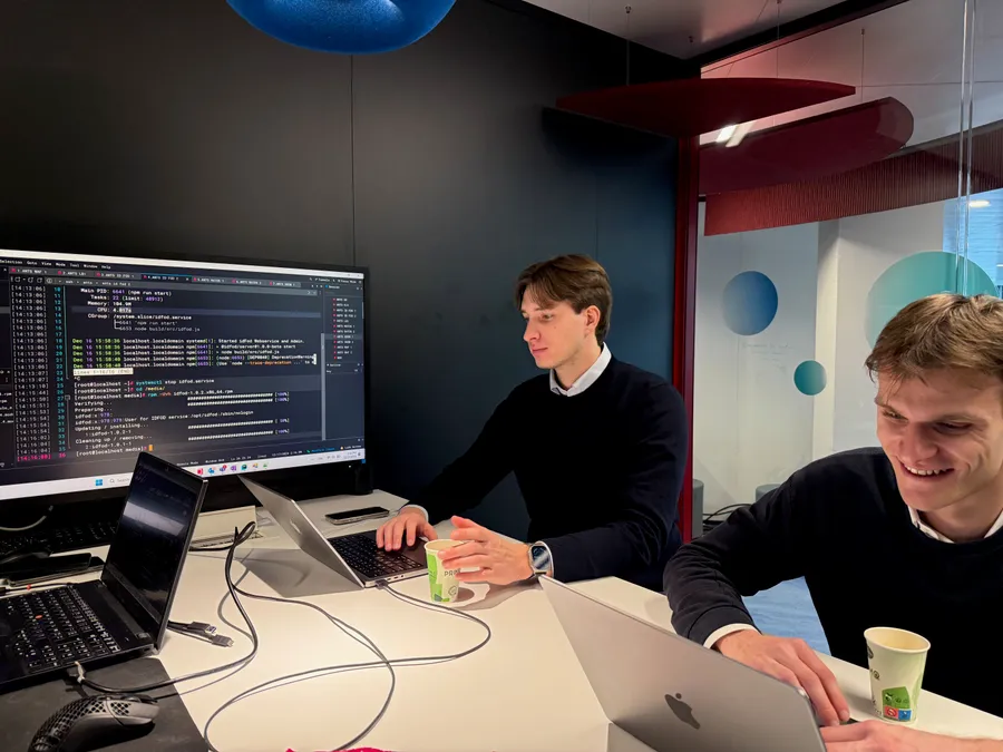 Des collègues réunis autour de leurs ordinateurs pour une revue de code.