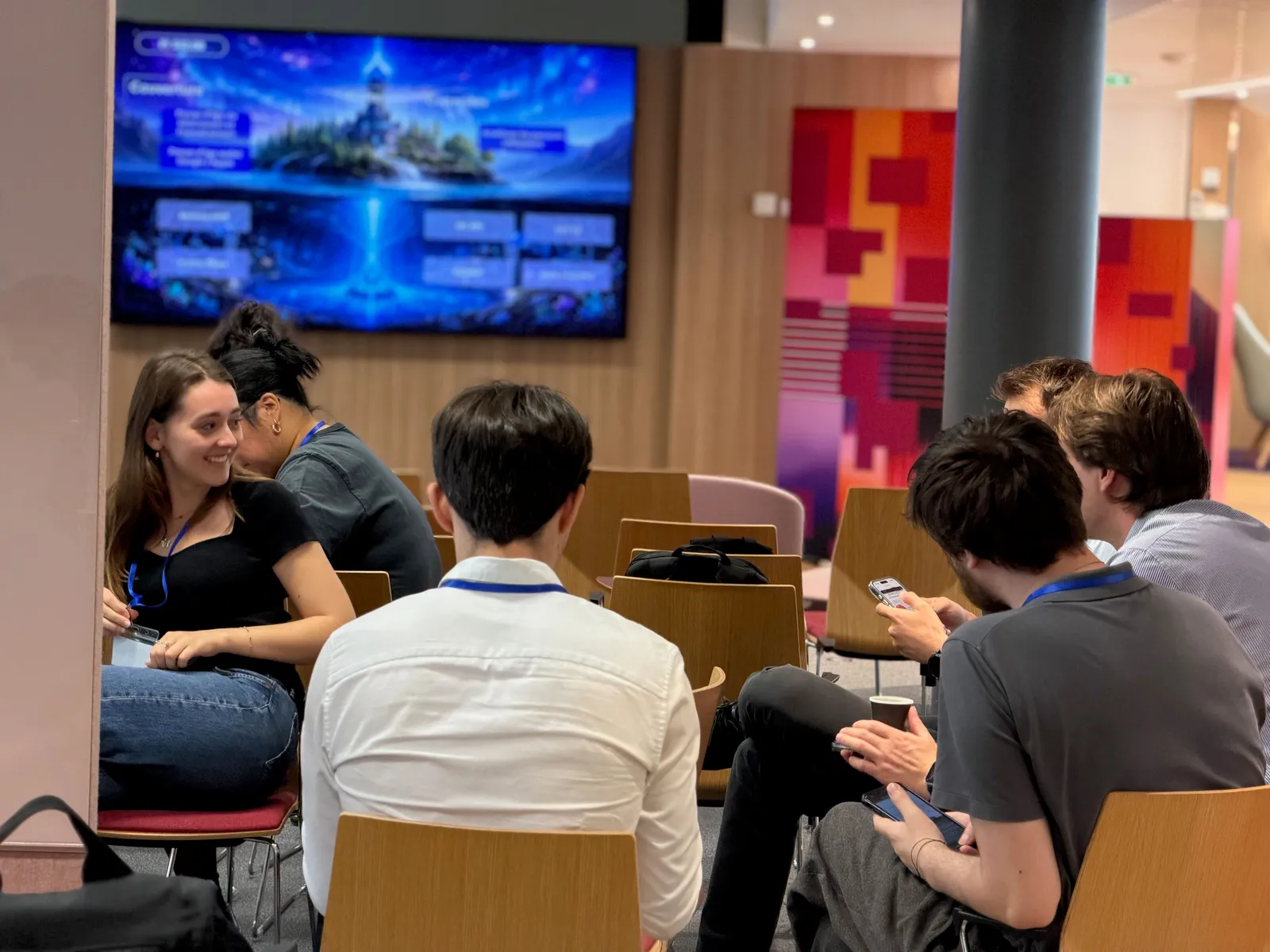 Des participants échangent en petit groupe, assis dans un espace de travail partagé.