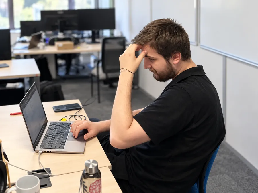 Lucas Kotevski, ingénieur cybersécurité Stelau, concentré sur son ordinateur au bureau.
