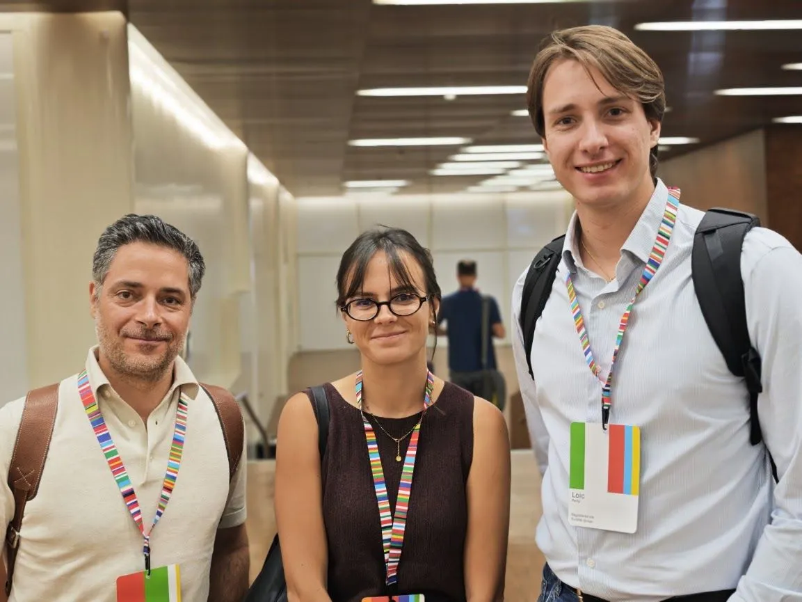 Trois participants à une conférence internationale sur l’identité numérique.